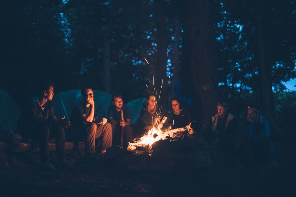 Group of people sitting around a campfire telling stories