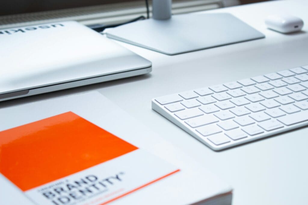 Brand identity guidelines document next to a MacBook keyboard